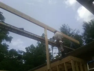 Carpenter setting a ridge beam over a new addition frame — Ice Dam Removal by Roofing Brothers in New Paris